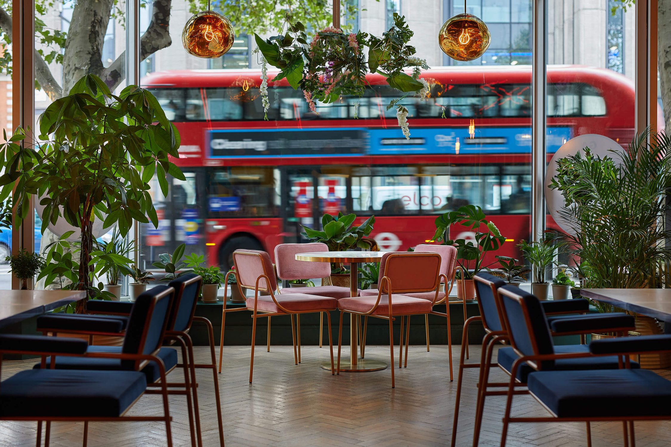 Large restaurant window view of red London bus